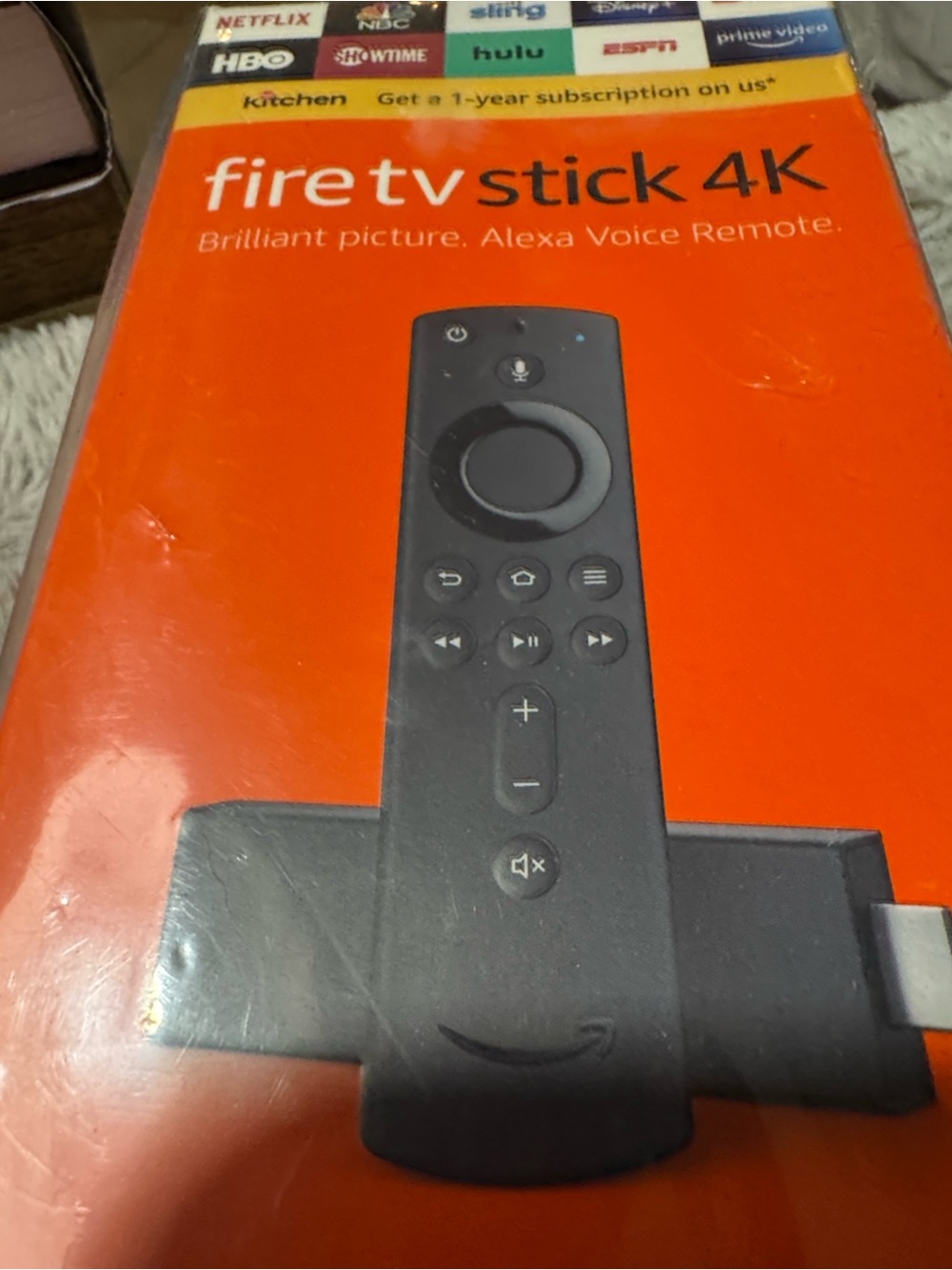 Amazon Fire TV Stick 4K in black and orange packaging